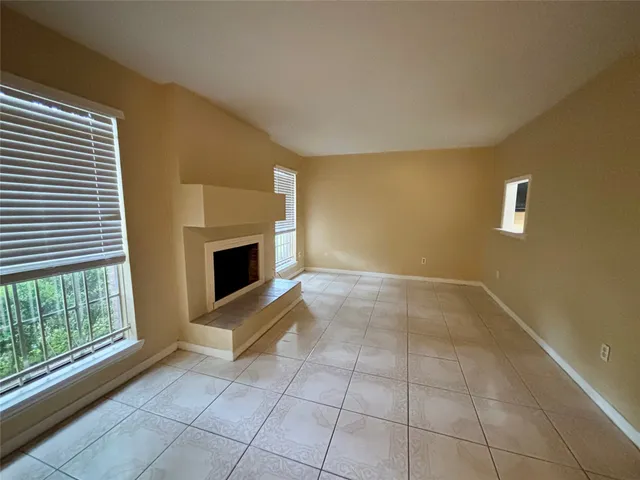 a view of an empty room with a fireplace and a window