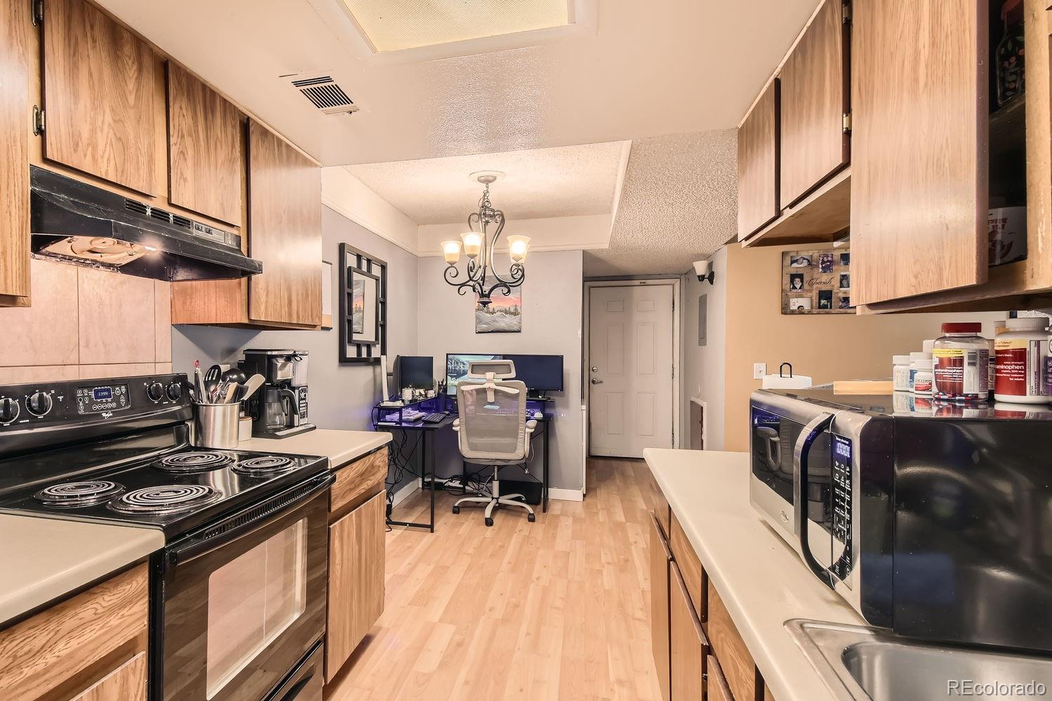 882 South Uravan Court Aurora, CO 80017 - Photo 16 of 33 a kitchen with stainless steel appliances granite countertop a stove top oven a sink dishwasher and cabinets with wooden floor