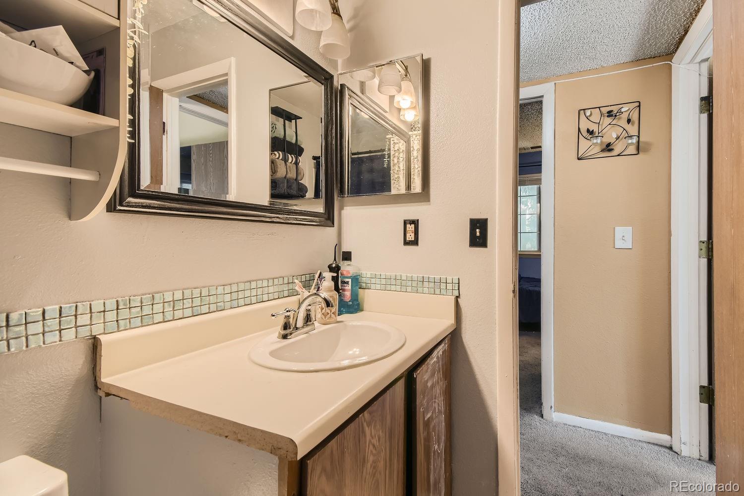 882 South Uravan Court Aurora, CO 80017 - Photo 19 of 33 a bathroom with a sink and a mirror