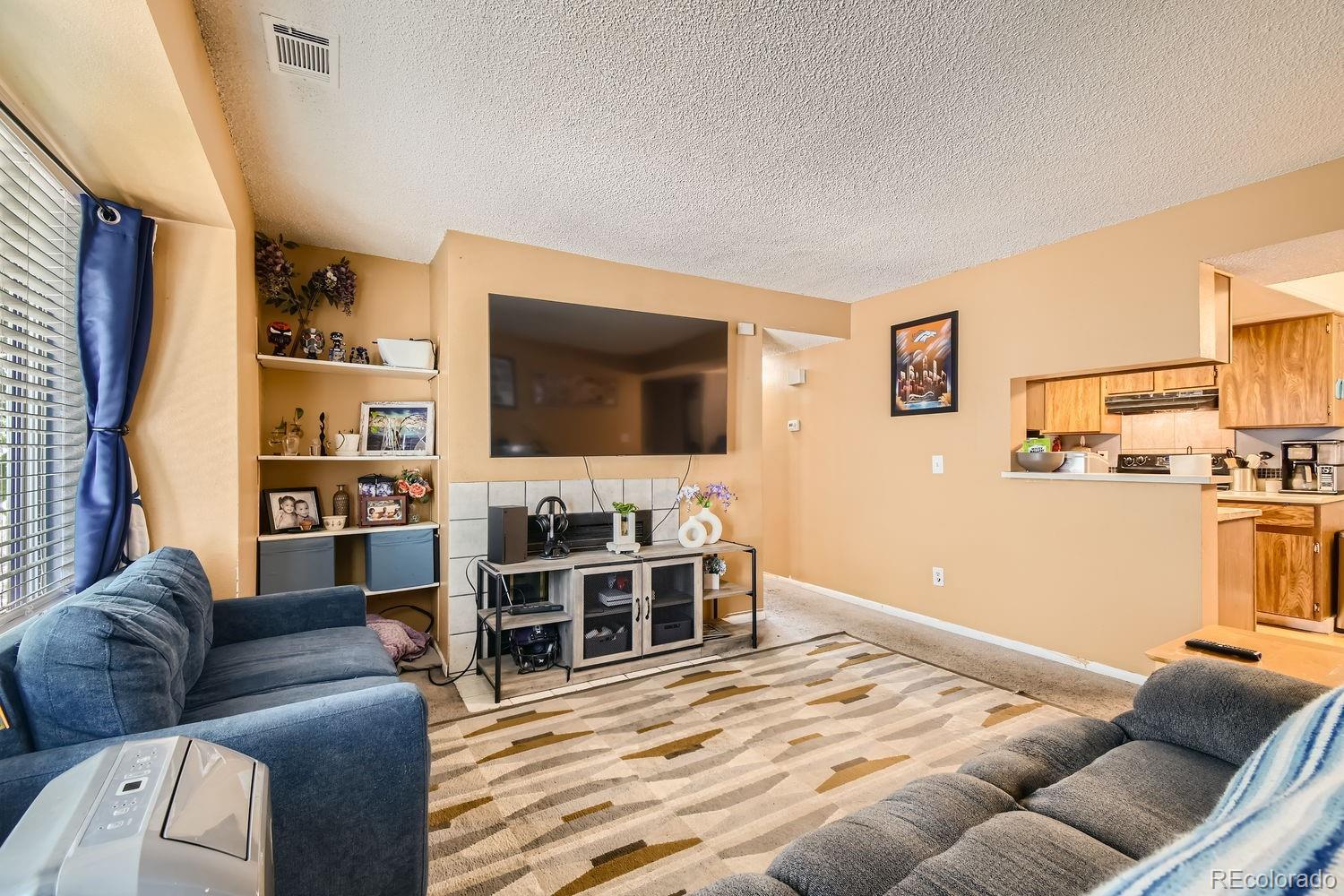882 South Uravan Court Aurora, CO 80017 - Photo 2 of 33 a living room with furniture and a flat screen tv