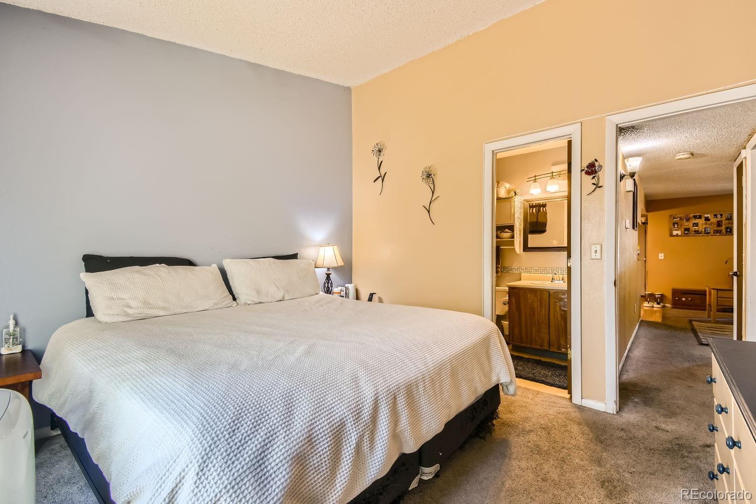 882 South Uravan Court Aurora, CO 80017 - Photo 10 of 33 a bedroom with a bed and a view of bathroom