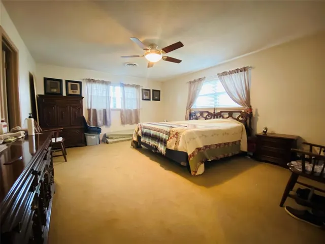a spacious bedroom with a bed and a chandelier