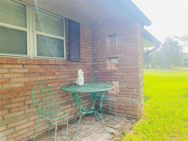 a view of a brick house with chairs in front of door