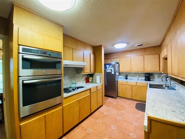 a kitchen with a sink cabinets and stainless steel appliances