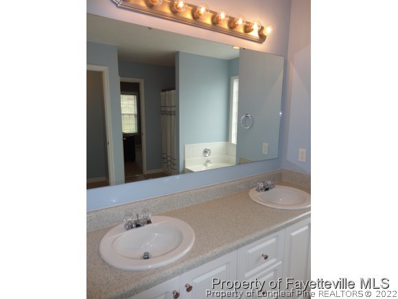 5432 Arnette Road Hope Mills, NC 28348 - Photo 12 of 25 a bathroom with a sink and a mirror