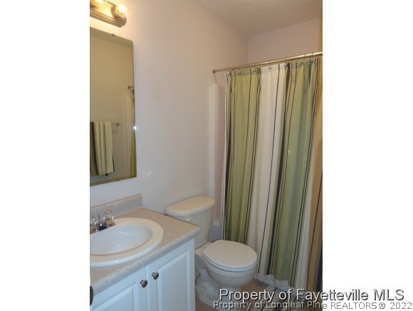 5432 Arnette Road Hope Mills, NC 28348 - Photo 19 of 25 a bathroom with a granite countertop sink toilet and shower