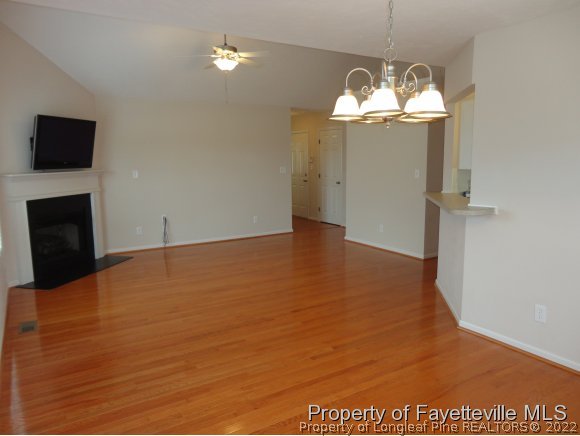 5432 Arnette Road Hope Mills, NC 28348 - Photo 6 of 25 a view of a room with a chandelier fan and wooden floor
