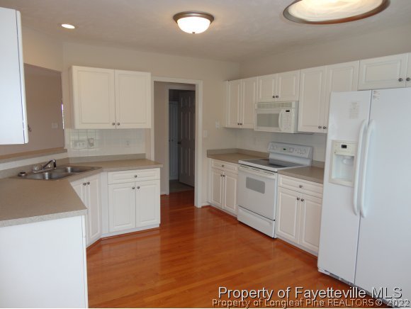 5432 Arnette Road Hope Mills, NC 28348 - Photo 7 of 25 a kitchen with white cabinets and white appliances