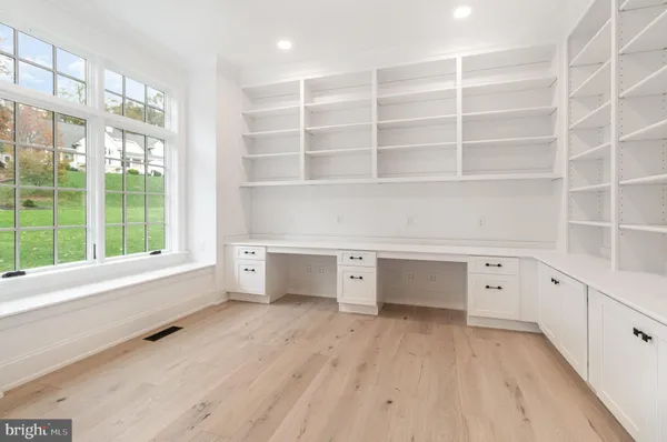 a view of an empty room with a window and cabinet