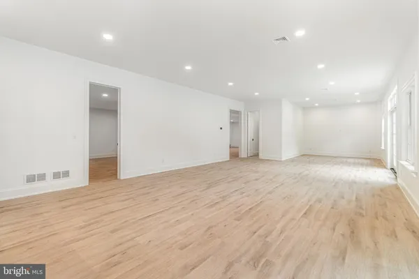 a kitchen with stainless steel appliances white cabinets and wooden floors