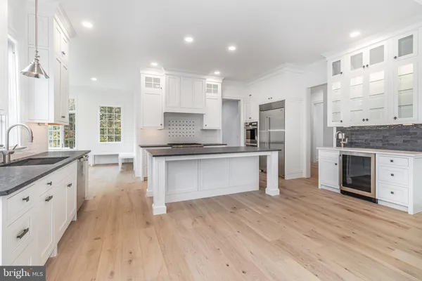 a large kitchen with granite countertop a large counter top a sink stainless steel appliances and cabinets