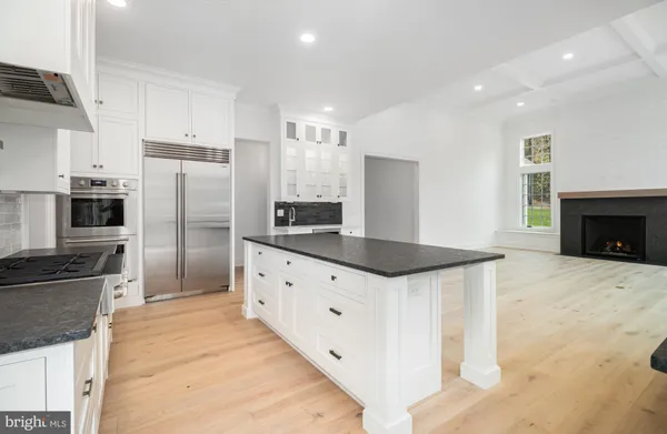 a kitchen with granite countertop a refrigerator and a stove top oven