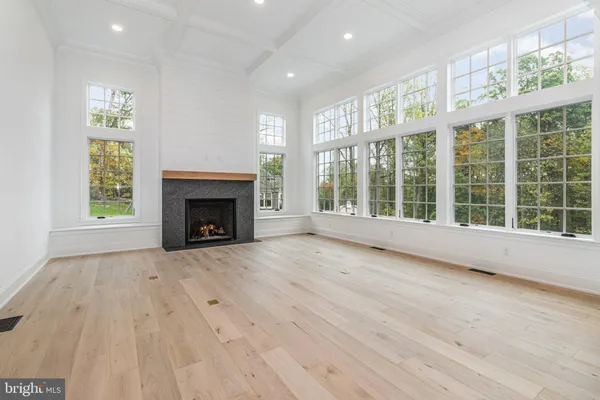 a view of an empty room with a window and fireplace