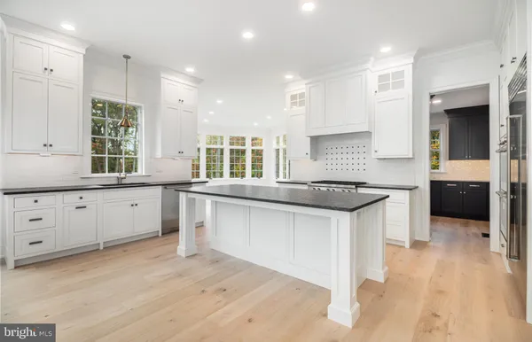 a kitchen with granite countertop a sink a counter space appliances and cabinets