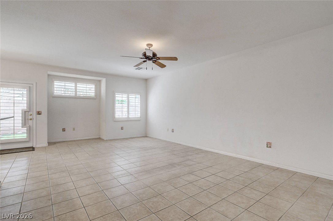 1479 Orange Jubilee Road Henderson, NV 89014 - Photo 6 of 36 A spacious living area features tiled flooring, multiple windows for natural light, and a ceiling fan.