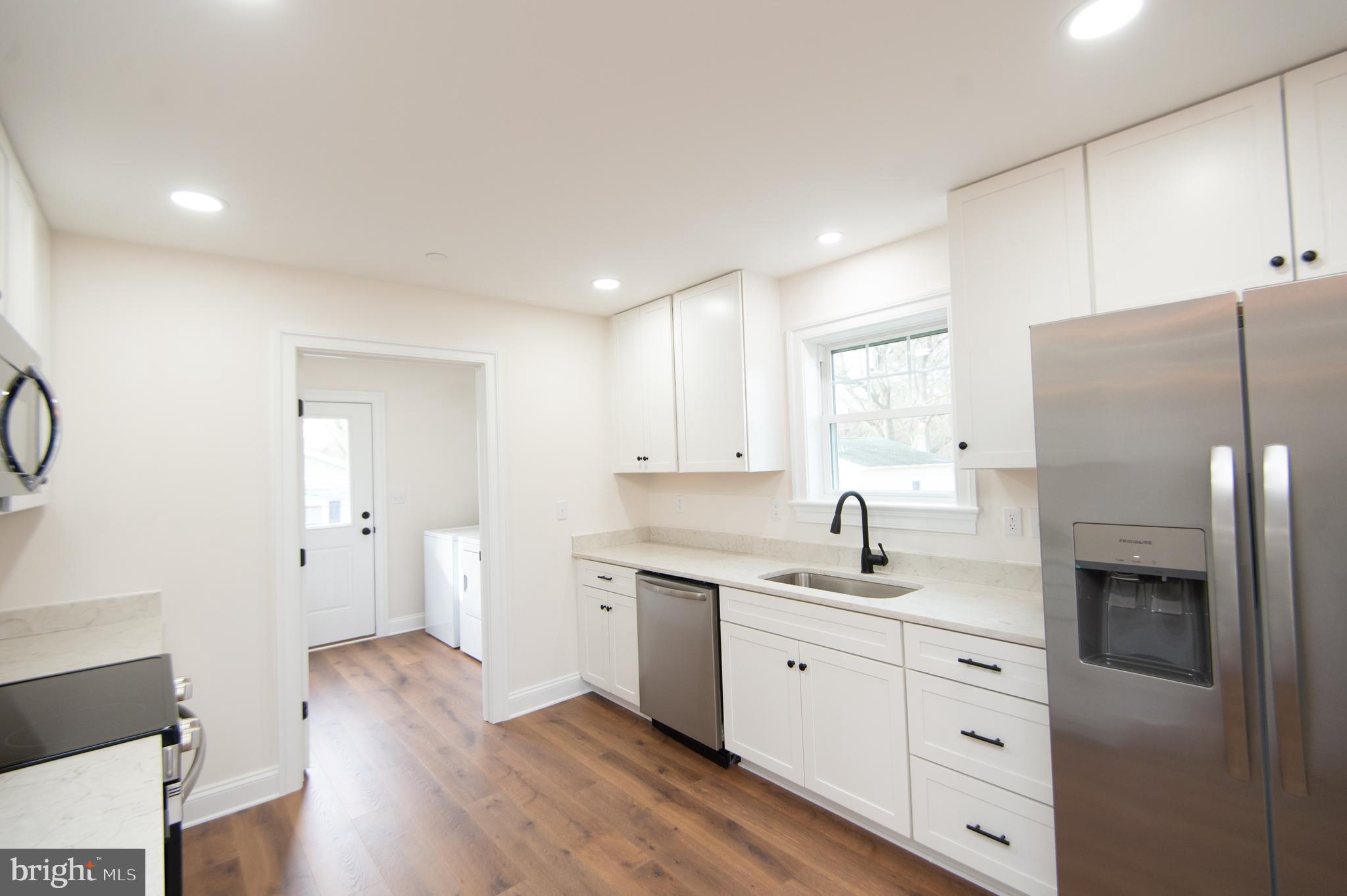 120 Academy Street Secretary, MD 21664 - Photo 12 of 46 a kitchen with white cabinets and stainless steel appliances