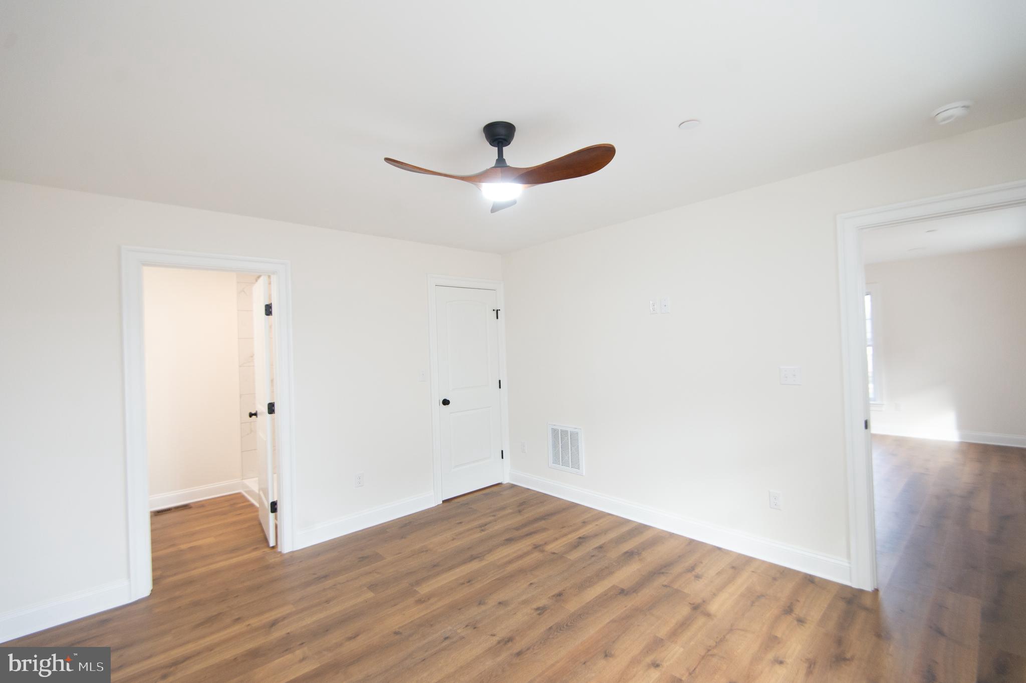120 Academy Street Secretary, MD 21664 - Photo 16 of 46 an empty room with wooden floor and ceiling fan