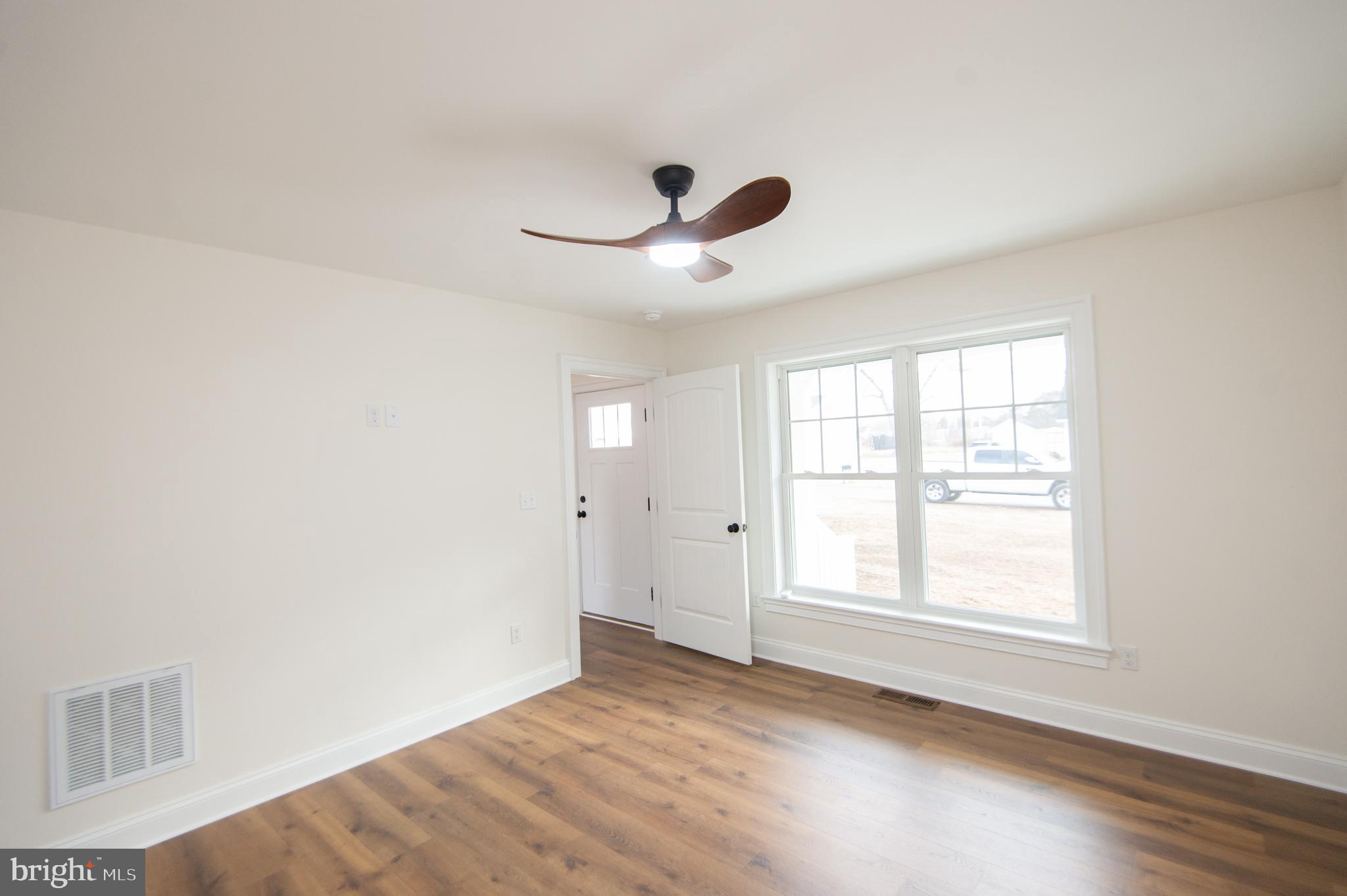 120 Academy Street Secretary, MD 21664 - Photo 17 of 46 a view of empty room with wooden floor and fan