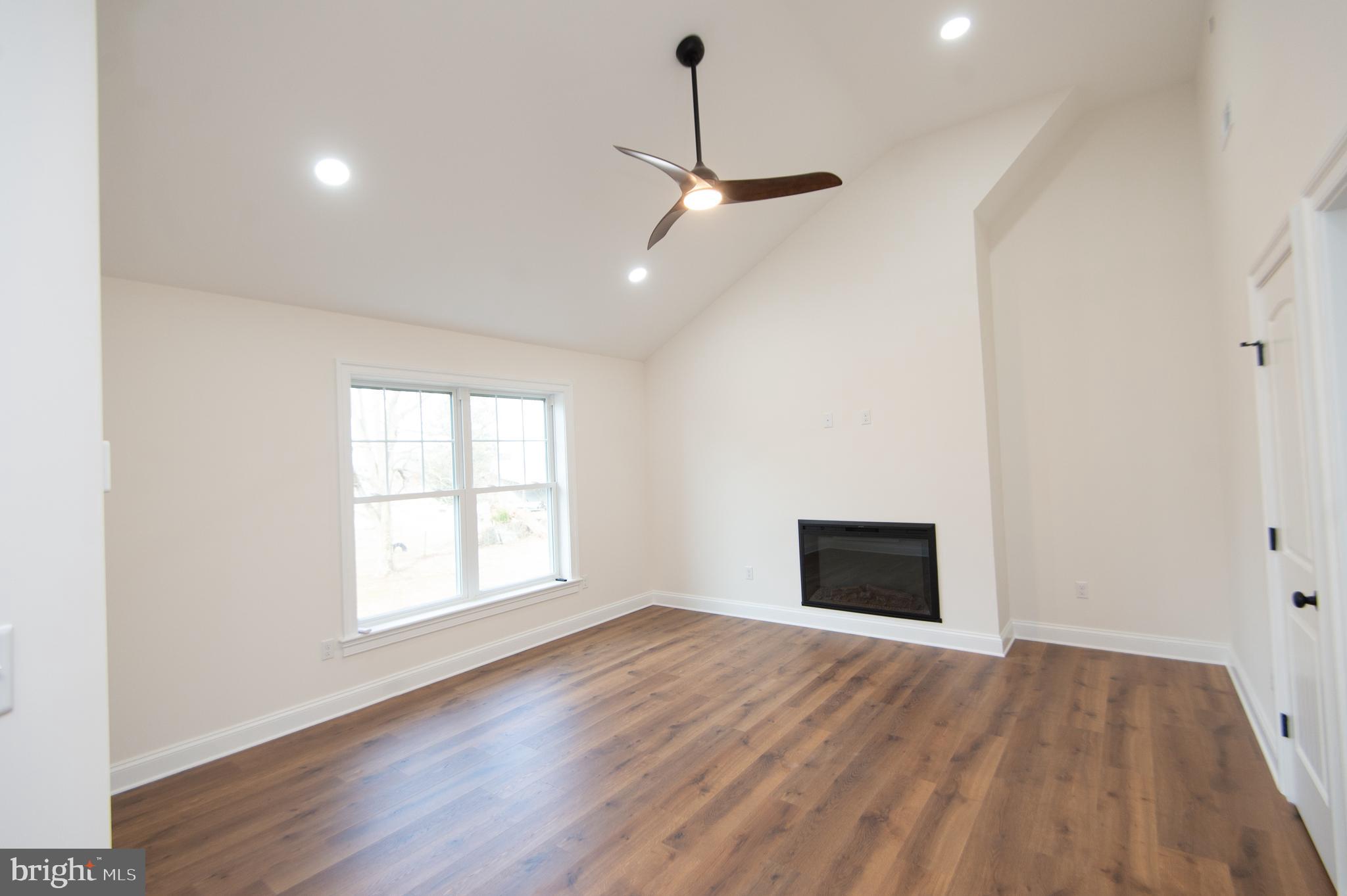 120 Academy Street Secretary, MD 21664 - Photo 21 of 46 an empty room with wooden floor ceiling fan and windows
