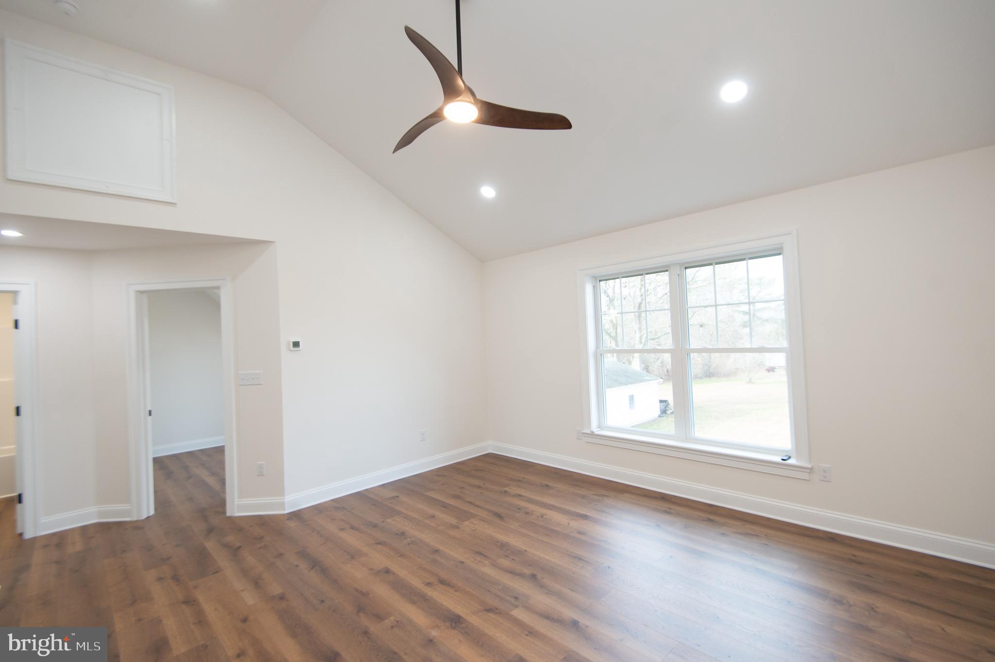 120 Academy Street Secretary, MD 21664 - Photo 24 of 46 an empty room with wooden floor ceiling fan and windows
