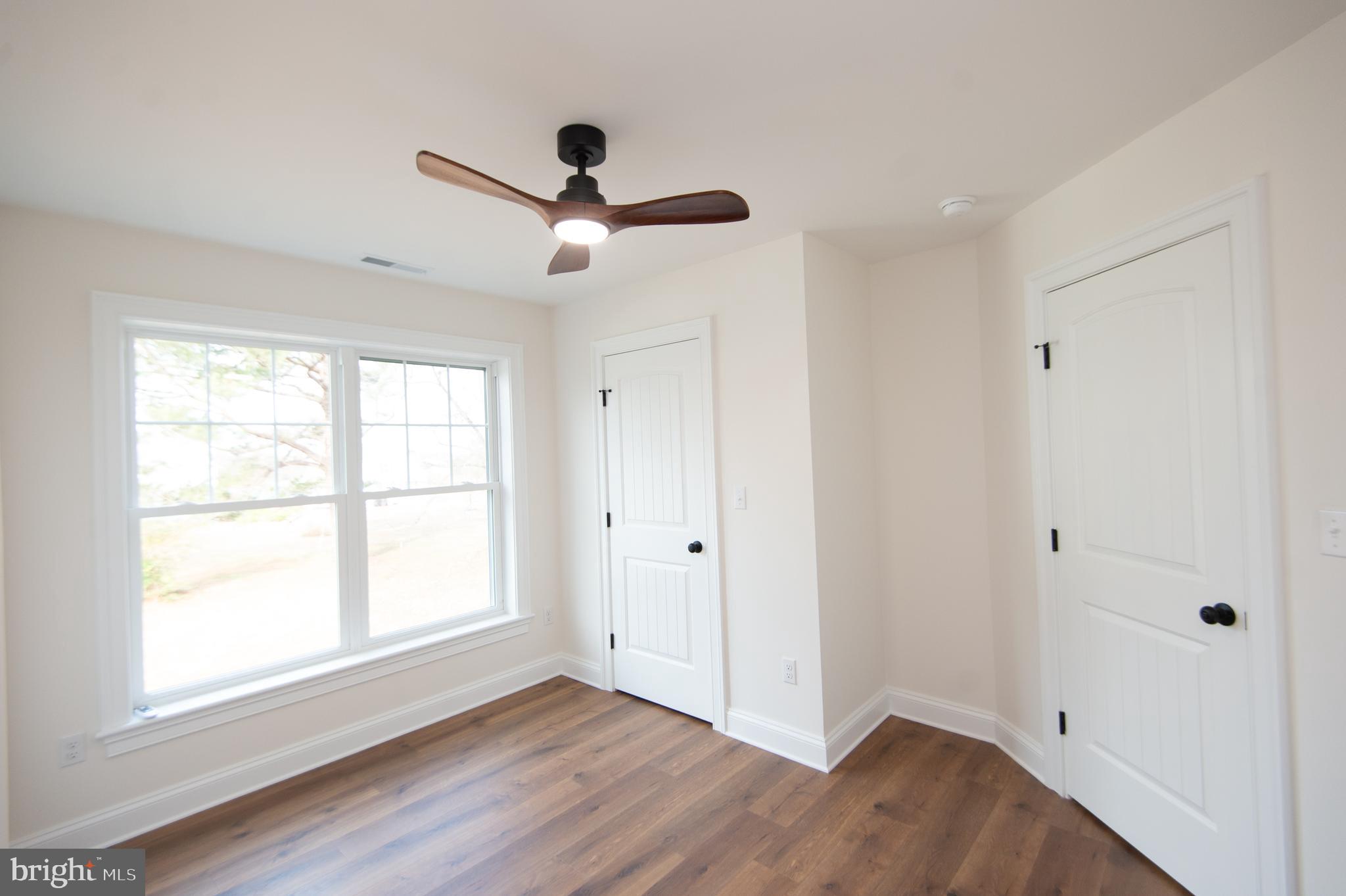 120 Academy Street Secretary, MD 21664 - Photo 31 of 46 a view of empty room with wooden floor and fan