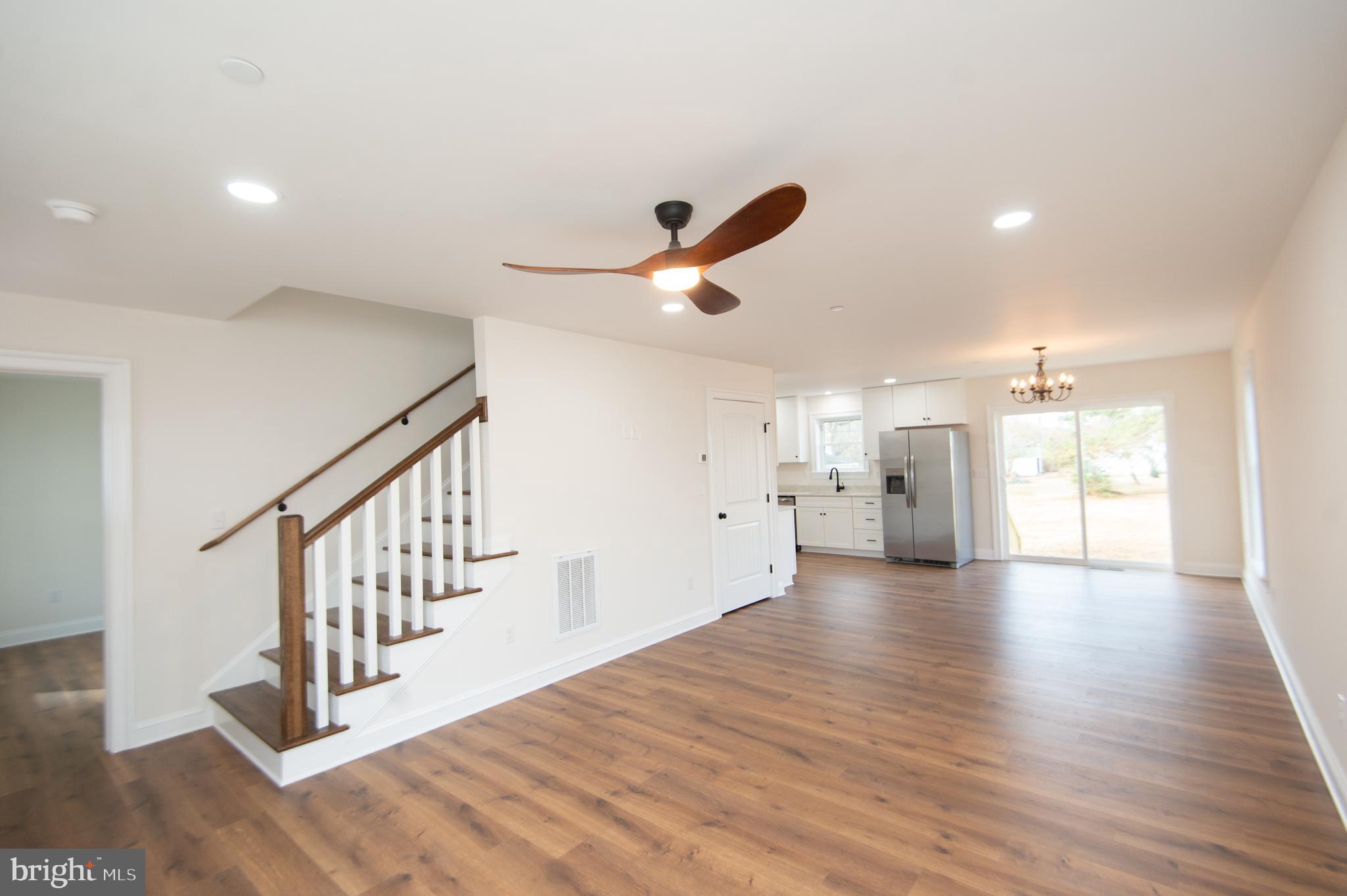 120 Academy Street Secretary, MD 21664 - Photo 7 of 46 a view of an empty room with wooden floor and a ceiling fan