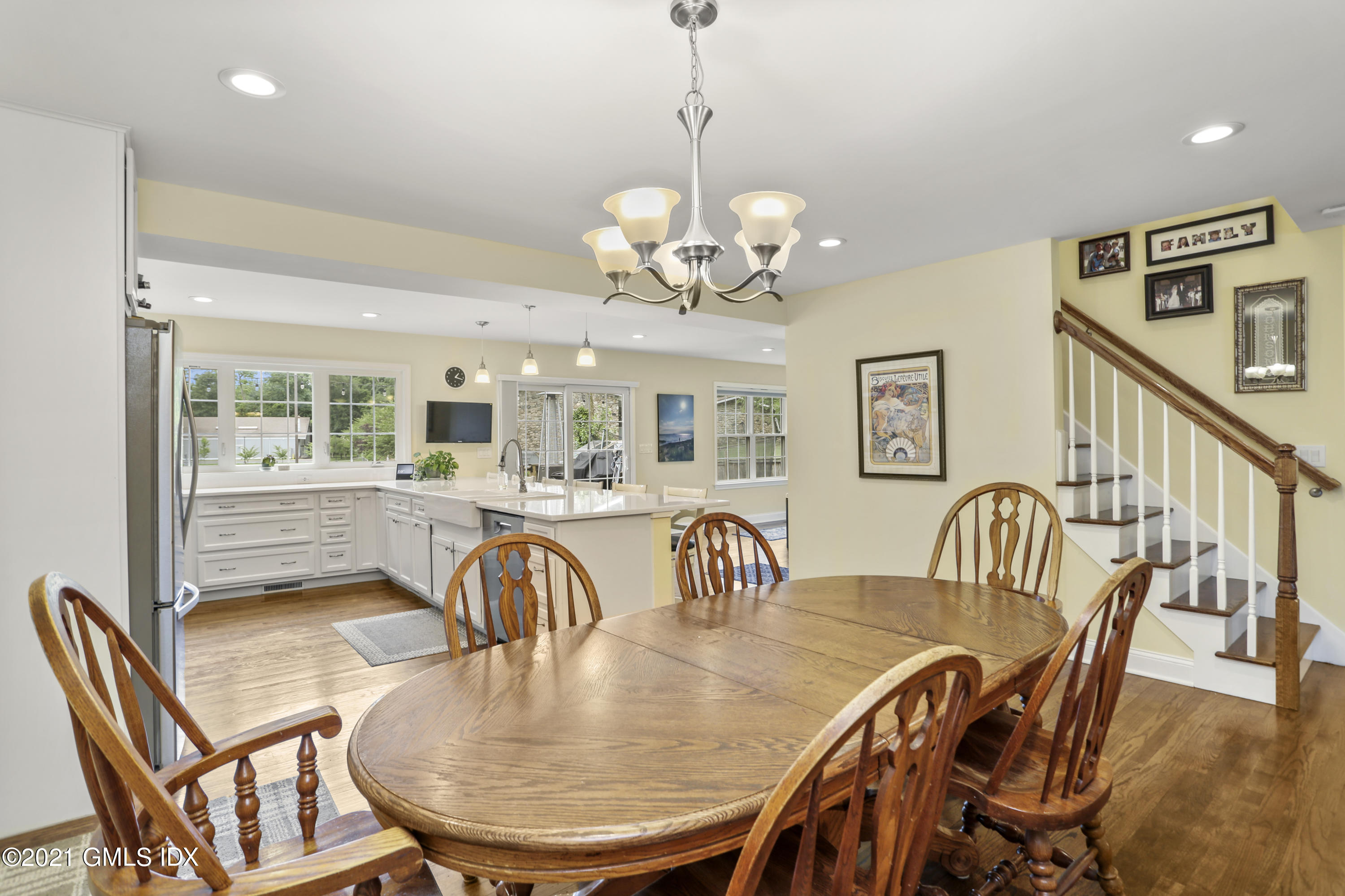 44 Bonwit Road Riverside, CT 06878 - Photo 8 of 22 a dining room with wooden floor a chandelier a glass table and chairs
