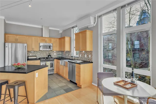 a kitchen with a refrigerator a table and chairs