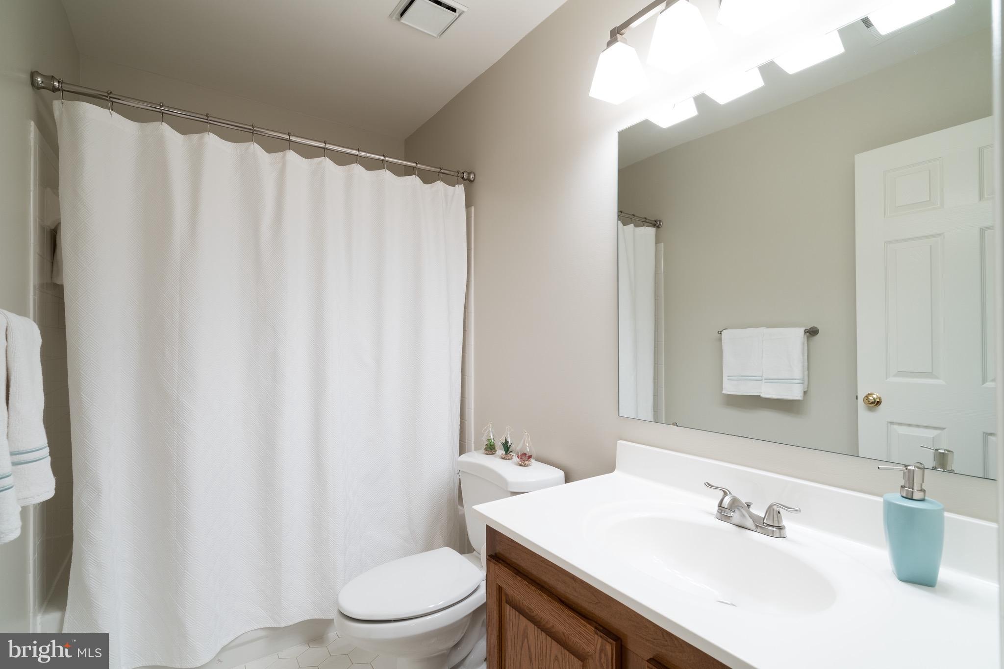 1211 Weatherstone Court Reston, VA 20194 - Photo 21 of 30 a bathroom with a sink a toilet and shower curtain