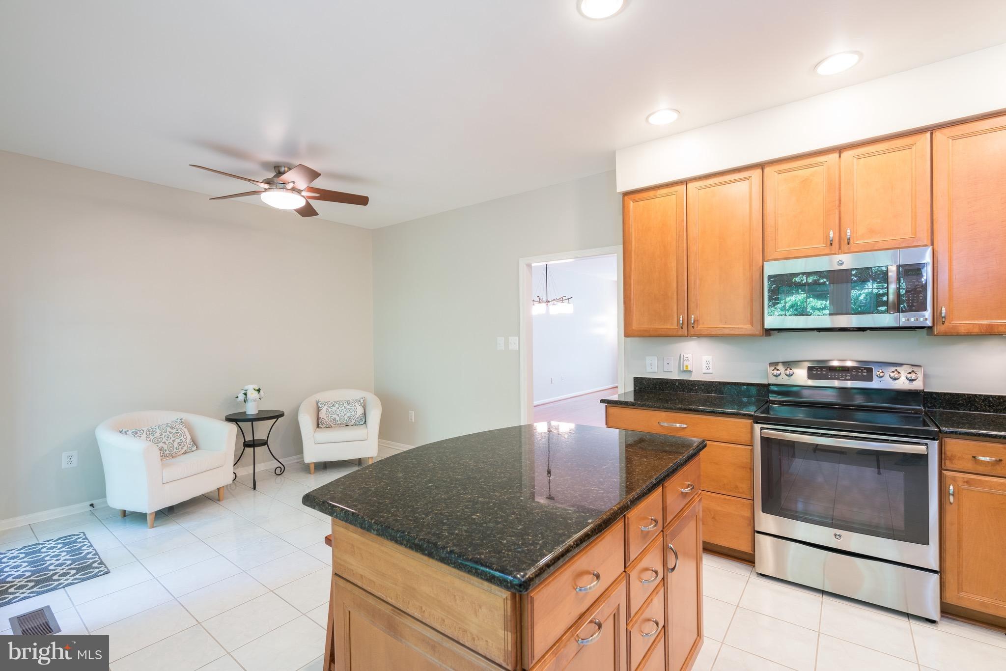 1211 Weatherstone Court Reston, VA 20194 - Photo 9 of 30 a kitchen with stainless steel appliances granite countertop a sink a stove a refrigerator cabinets and living room view
