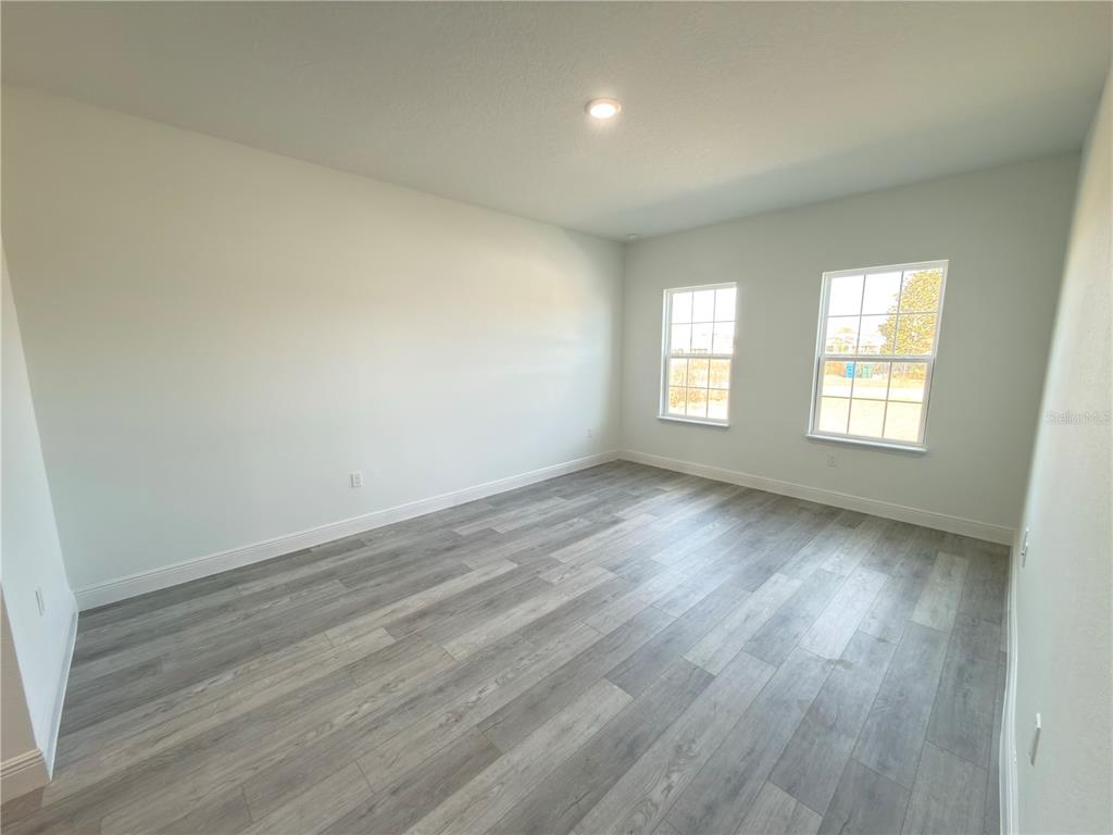 4650 Southwest 139th Place Ocala, FL 34473 - Photo 12 of 49 an empty room with wooden floor and windows