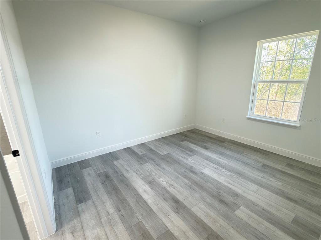 4650 Southwest 139th Place Ocala, FL 34473 - Photo 29 of 49 an empty room with wooden floor and windows