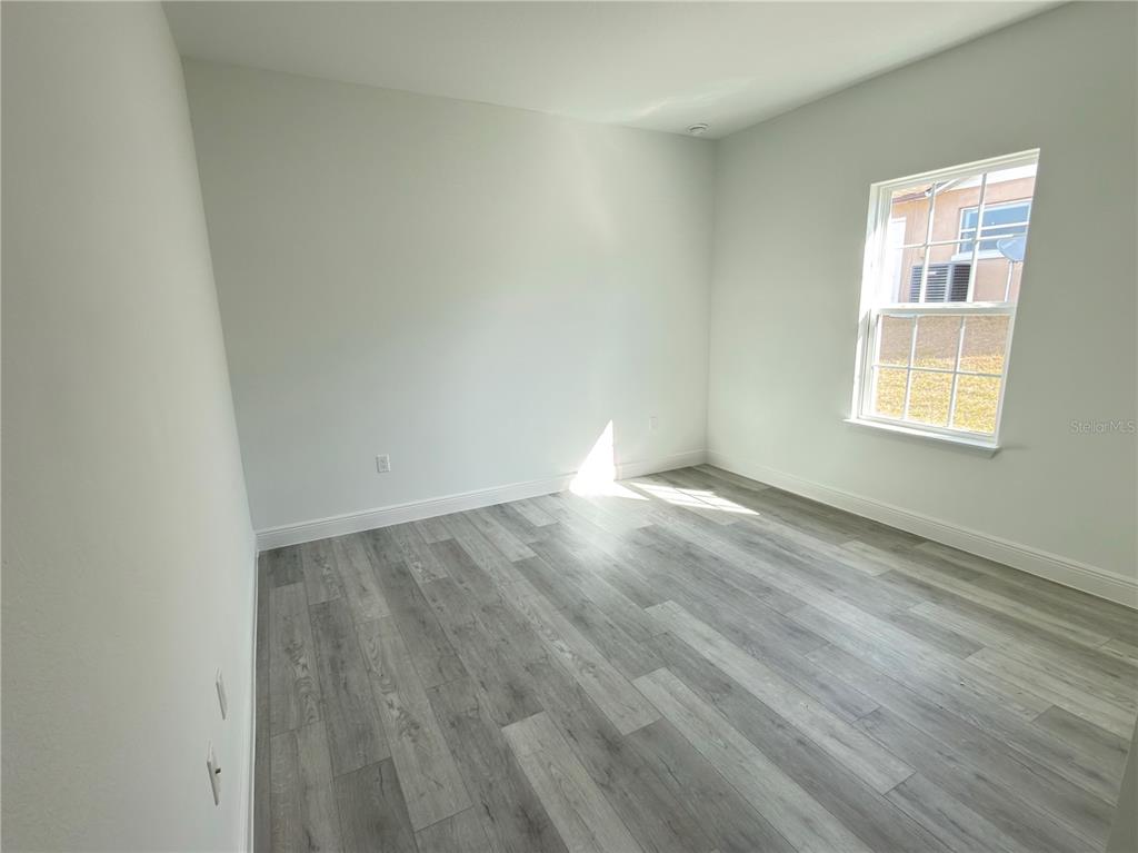 4650 Southwest 139th Place Ocala, FL 34473 - Photo 38 of 49 an empty room with wooden floor and windows