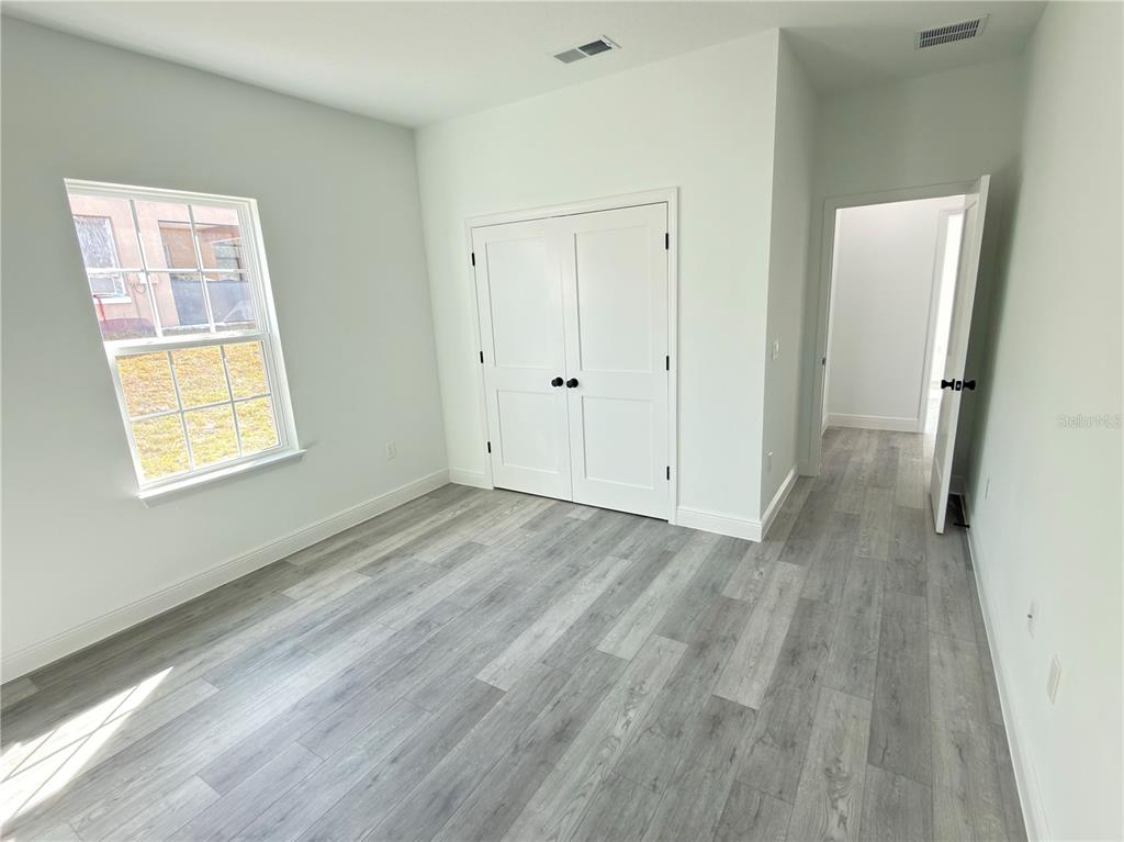 4650 Southwest 139th Place Ocala, FL 34473 - Photo 39 of 49 a view of an empty room with wooden floor and a window