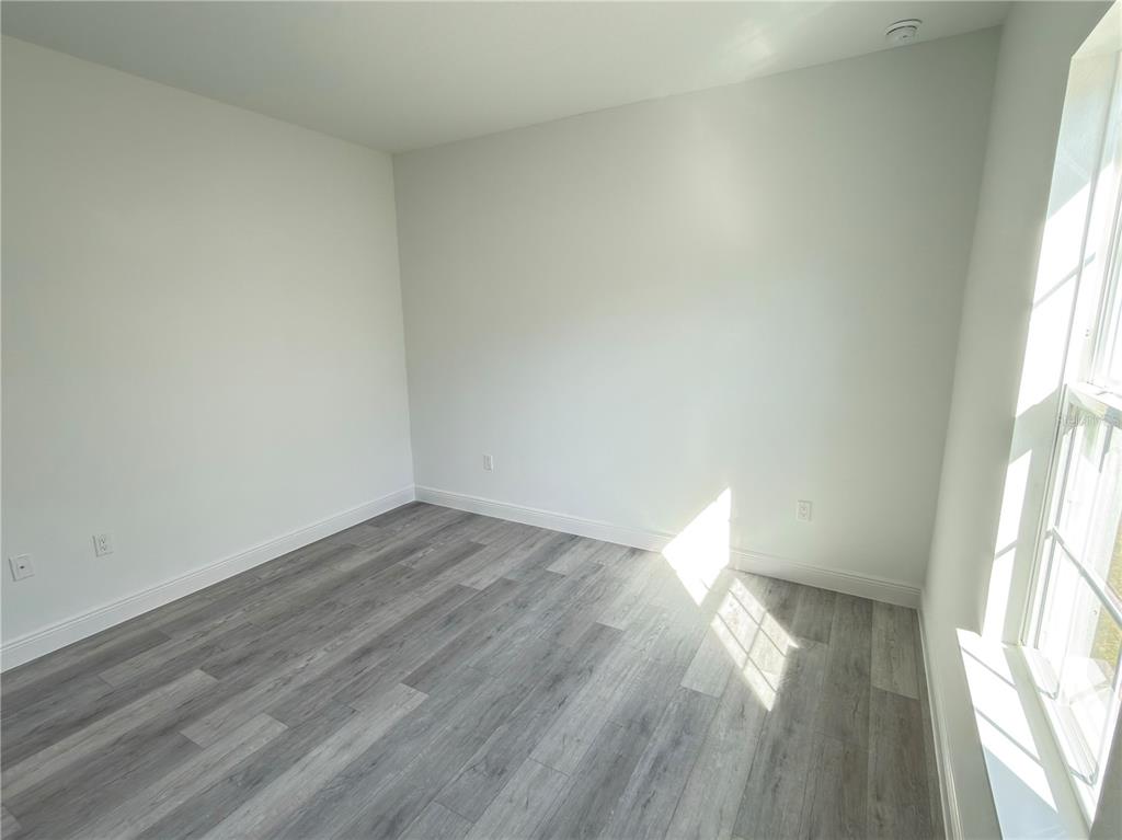 4650 Southwest 139th Place Ocala, FL 34473 - Photo 40 of 49 an empty room with wooden floor and windows