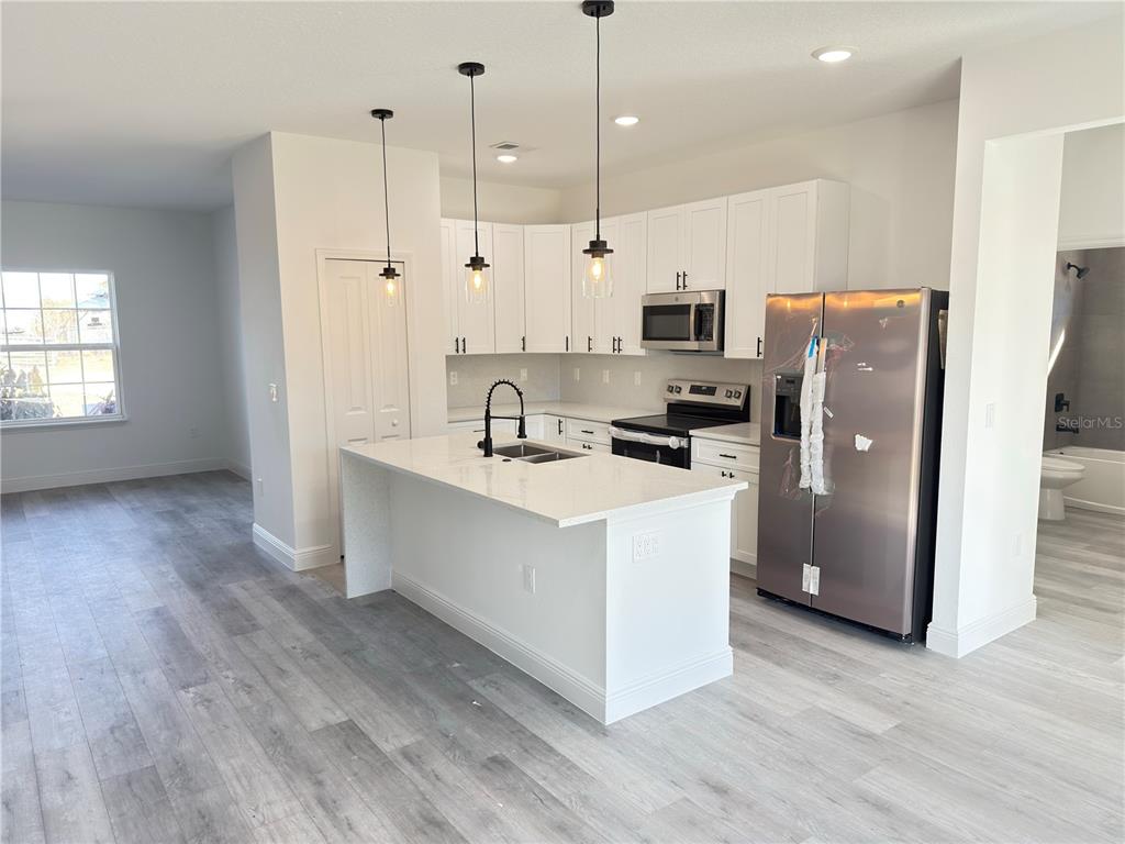 4650 Southwest 139th Place Ocala, FL 34473 - Photo 7 of 49 a kitchen with stainless steel appliances a refrigerator a sink a stove a microwave and wooden floor