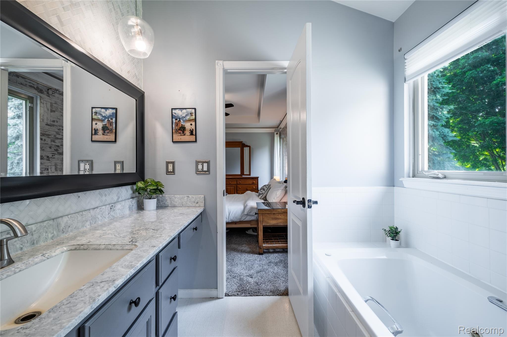3483 Lahring Road Linden, MI 48451 - Photo 10 of 34 Bathroom featuring a dual vanity with light-toned stone countertop, undermount sink, and dark cabinetry