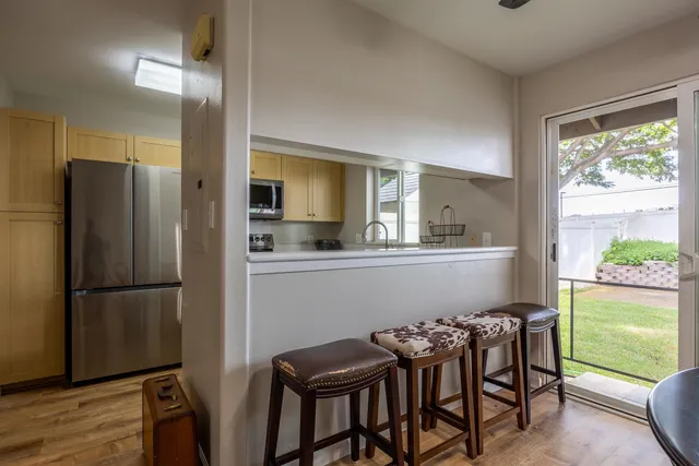 a kitchen with a table chairs refrigerator and microwave