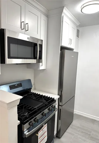 a kitchen with granite countertop a stove and a microwave