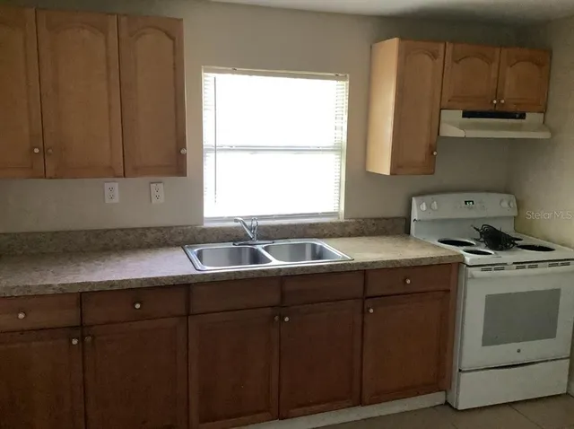 a kitchen with a sink cabinets and window