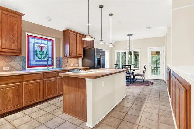 a open kitchen with kitchen island granite countertop a sink counter top space and a view of living room