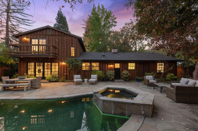 a view of a house with swimming pool and sitting area