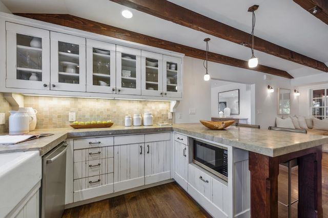 a kitchen with lots of counter and chairs