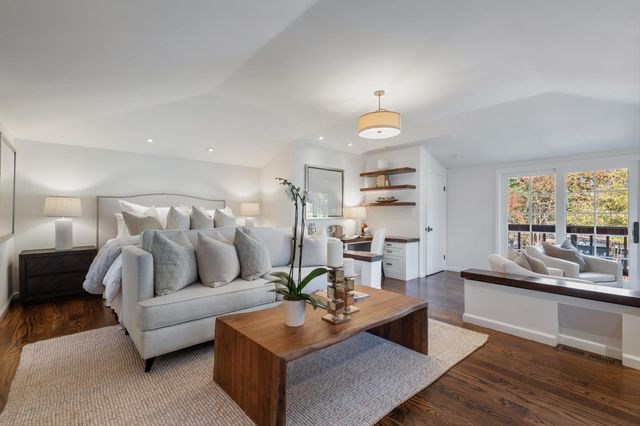 a dining room with wooden floor a chandelier a wooden table and chairs