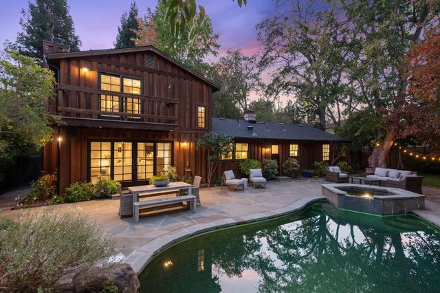 a view of a house with swimming pool and sitting area