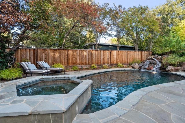 a view of a backyard with couches and a fire pit and wooden fence