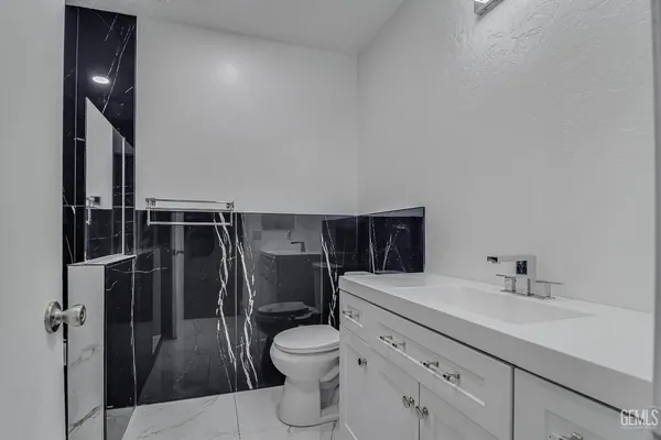 a bathroom with a toilet sink and mirror