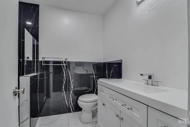 a bathroom with a toilet sink and mirror