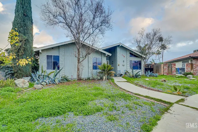 a view of a house with a yard and flower plants