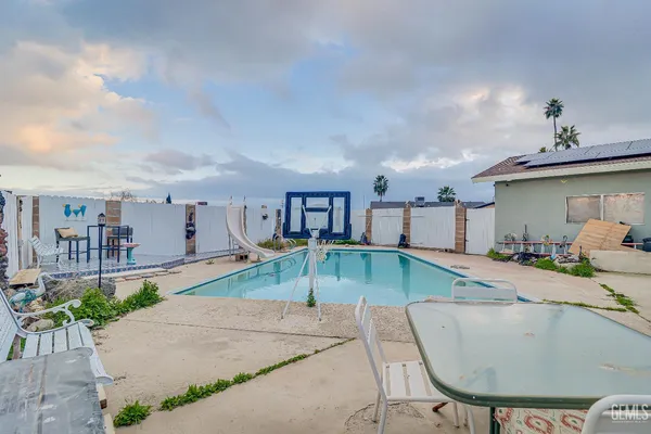 a view of a house with swimming pool and sitting area
